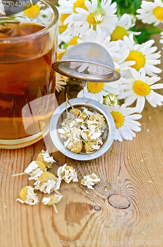 Image of Herbal tea from chamomile dry in a strainer with mug