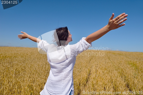 Image of young woman with spreading arms to sky
