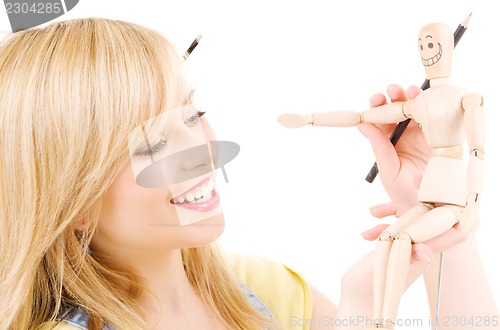 Image of happy teenage girl with wooden model dummy