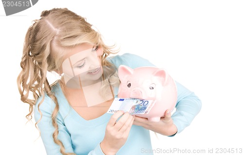 Image of lovely woman with piggy bank and money