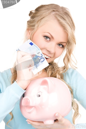Image of lovely woman with piggy bank and money