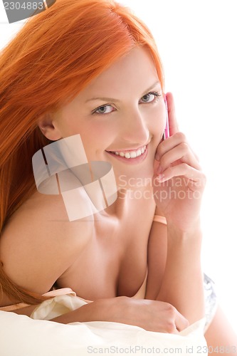 Image of happy redhead woman with cell phone