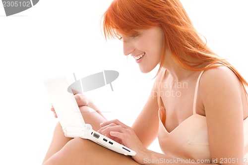 Image of happy redhead woman with laptop computer