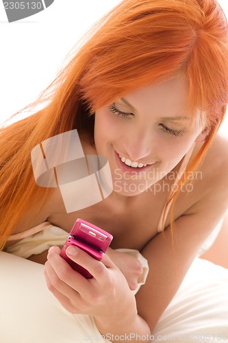 Image of happy redhead woman with cell phone