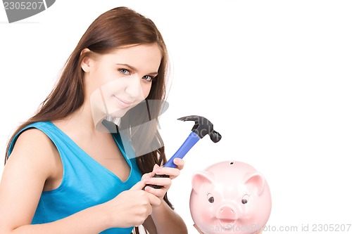 Image of teenage girl with piggy bank and hammer