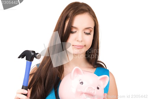 Image of teenage girl with piggy bank and hammer