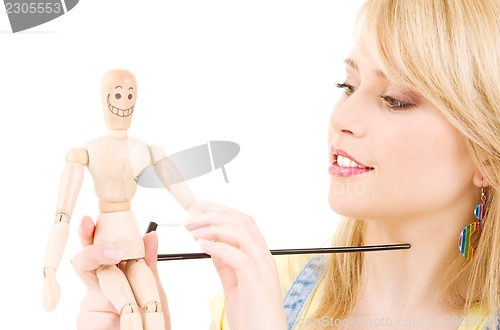 Image of happy teenage girl with wooden model dummy