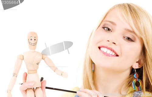 Image of happy teenage girl with wooden model dummy