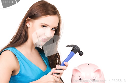 Image of teenage girl with piggy bank and hammer