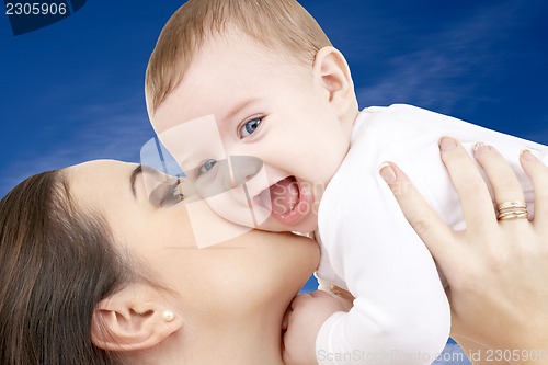 Image of happy mother with baby boy over blue sky