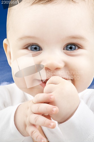 Image of baby face over blue sky