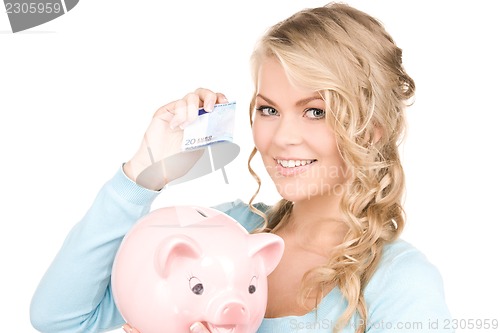 Image of lovely woman with piggy bank and money