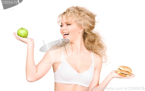 Image of woman choosing between burger and apple
