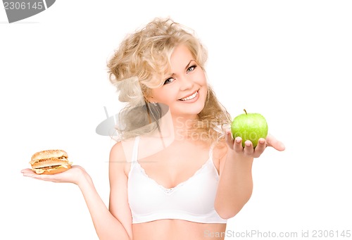 Image of woman choosing between burger and apple