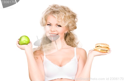 Image of woman choosing between burger and apple