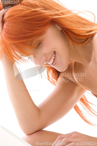 Image of happy redhead woman with laptop computer