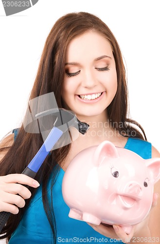 Image of teenage girl with piggy bank and hammer