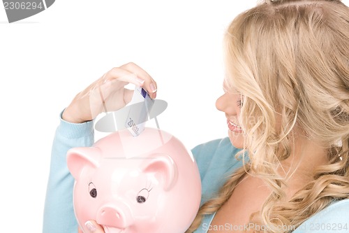 Image of lovely woman with piggy bank and money