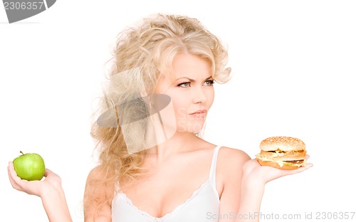 Image of woman choosing between burger and apple