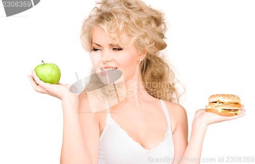 Image of woman choosing between burger and apple