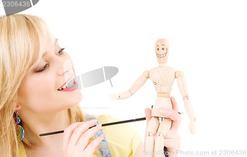 Image of happy teenage girl with wooden model dummy