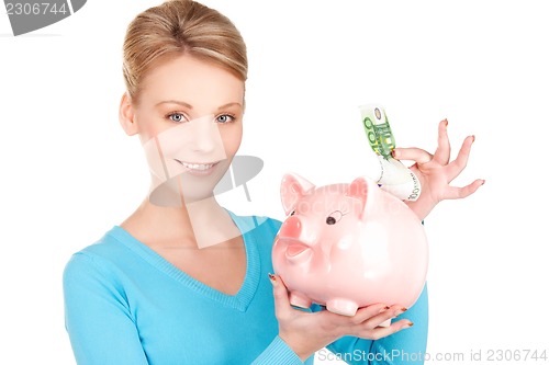 Image of lovely woman with piggy bank and money