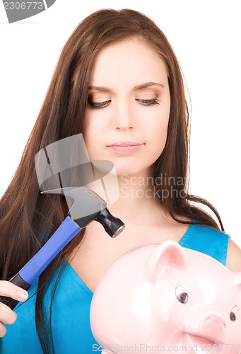 Image of teenage girl with piggy bank and hammer