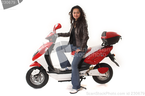 Image of woman riding electric scooter with no helmet