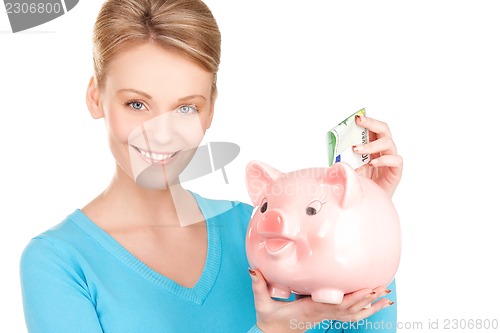 Image of lovely woman with piggy bank and money
