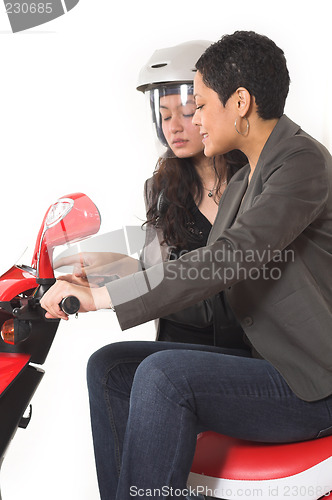 Image of couple girls talking on  scooter