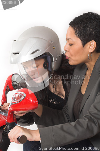 Image of couple girls talking on  scooter