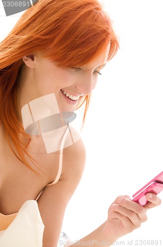 Image of happy redhead woman with cell phone