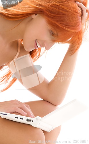 Image of happy redhead woman with laptop computer