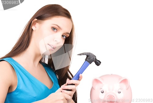 Image of teenage girl with piggy bank and hammer