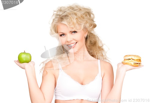 Image of woman choosing between burger and apple