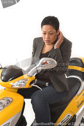 Image of woman riding electric scooter with no helmet