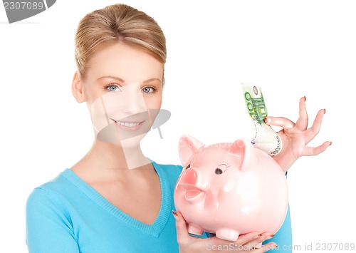 Image of lovely woman with piggy bank and money