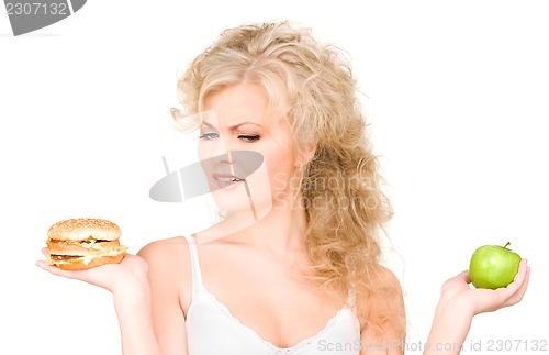 Image of woman choosing between burger and apple