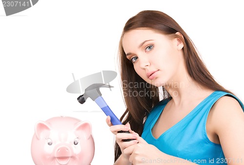 Image of teenage girl with piggy bank and hammer