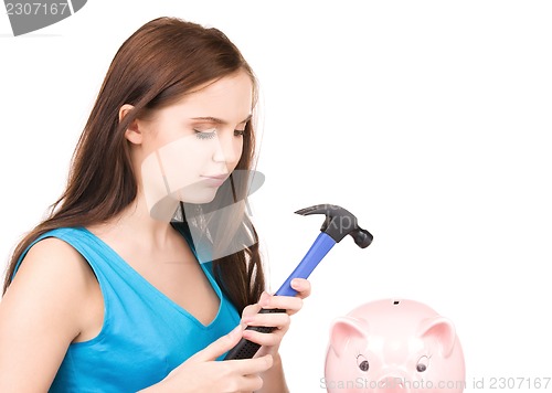 Image of teenage girl with piggy bank and hammer