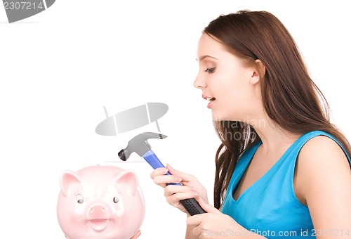 Image of teenage girl with piggy bank and hammer