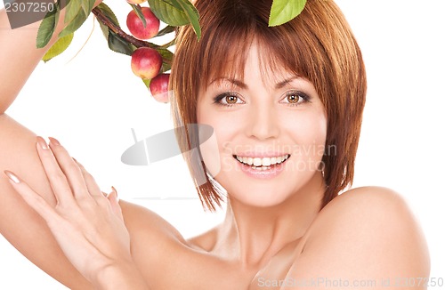 Image of happy woman with apple twig