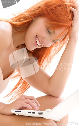 Image of happy redhead woman with laptop computer