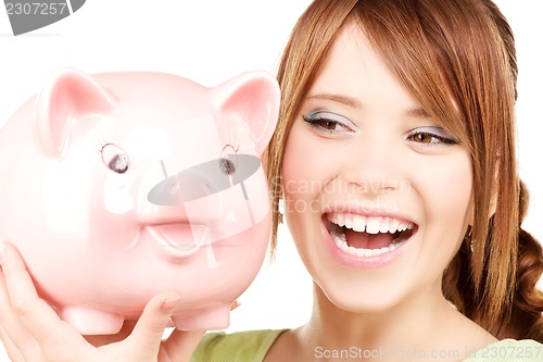 Image of lovely teenage girl with piggy bank