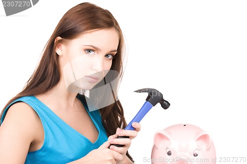 Image of teenage girl with piggy bank and hammer