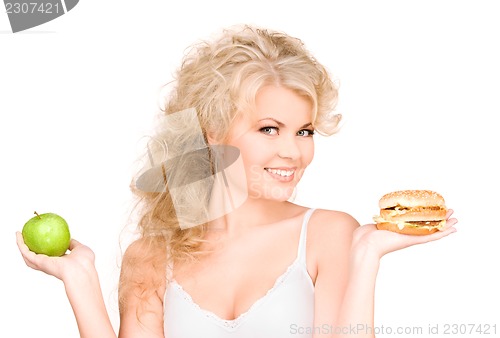 Image of woman choosing between burger and apple