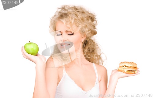 Image of woman choosing between burger and apple