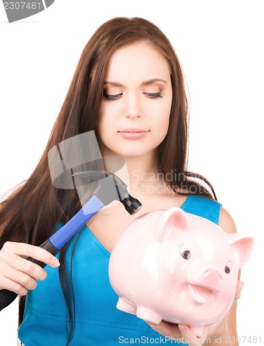 Image of teenage girl with piggy bank and hammer