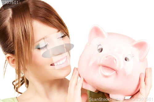 Image of lovely teenage girl with piggy bank