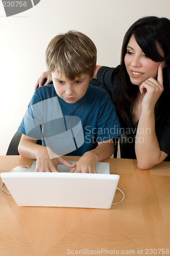 Image of Child using laptop while adult supervises